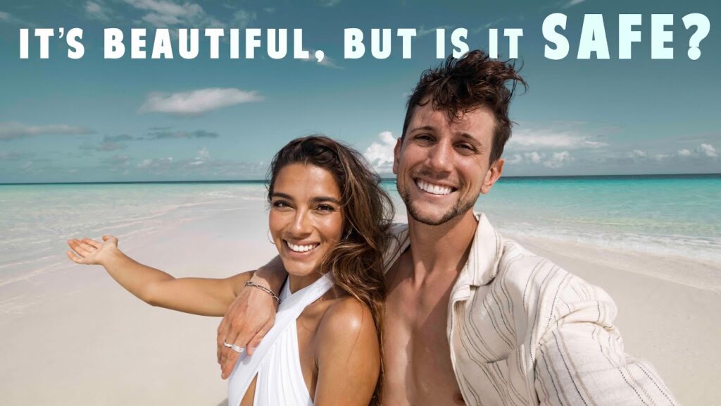 a man and woman taking a selfie on a beach:Africa